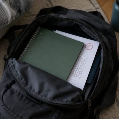 Copie à moitié cachée dans un cartable, enfant qui cache ses notes
